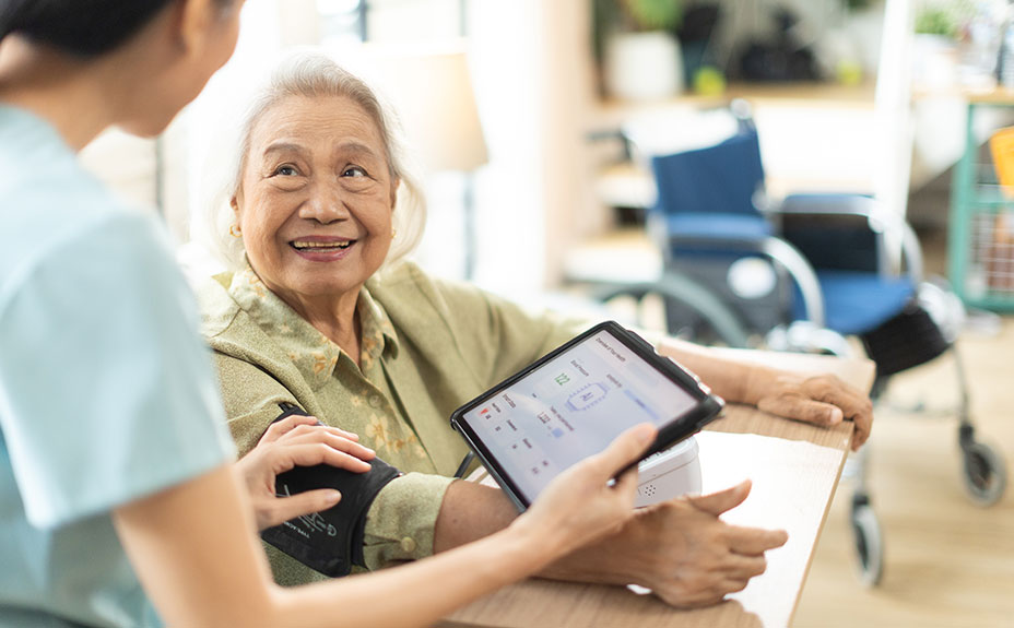 nurse taking blood pressure with tablet live recording results