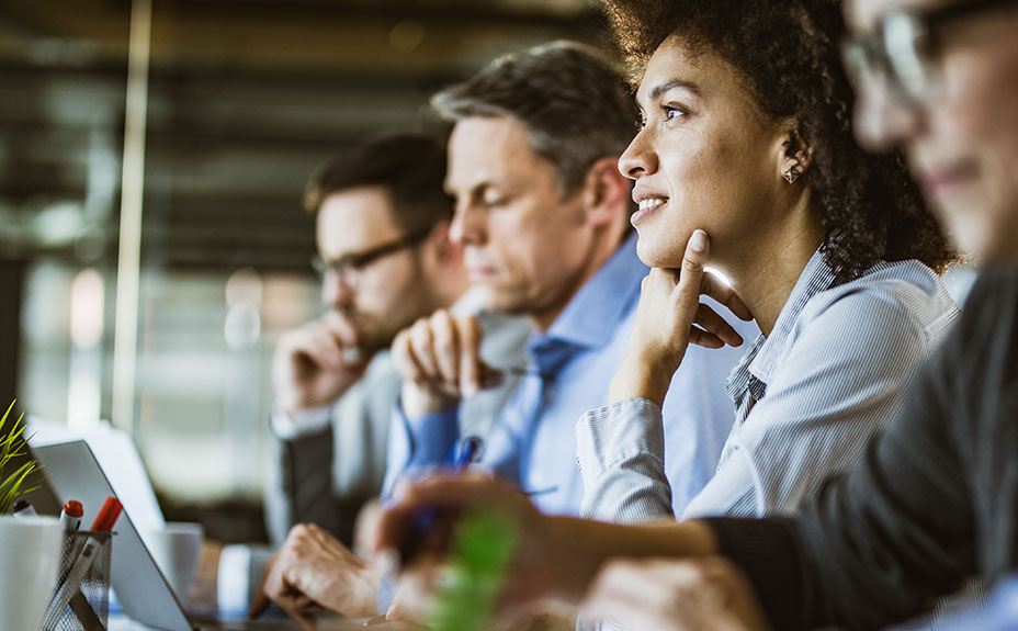 Pensive Black woman among colleagues