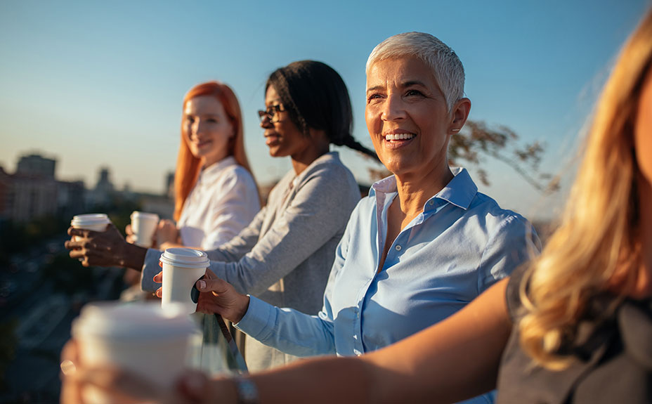 diverse group of women having coffee on a rooftop
