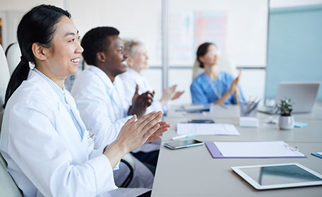 Doctors applauding in a conference room