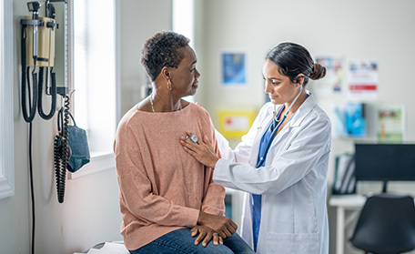 doctor using a stethoscope on patient