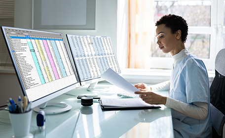 person working at a computer with 2 large monitors