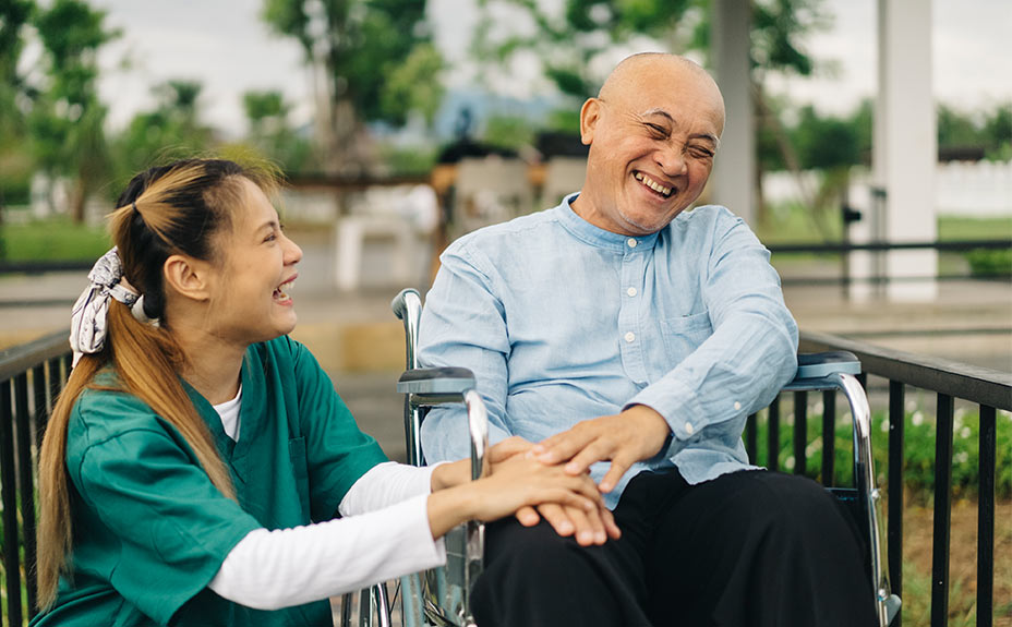 Asian senior in good spirits talking with a nurse