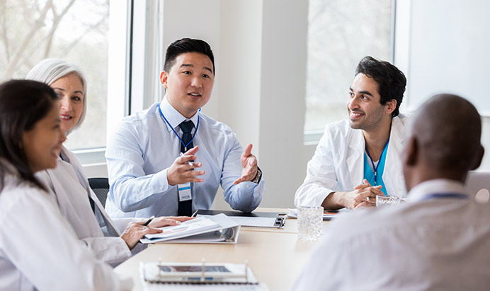 Hospital administrator conducts staff meeting